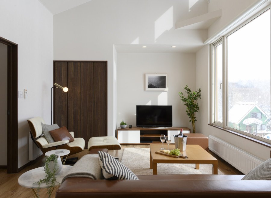 Relax in this stylish living room, featuring floor-to-ceiling windows offering stunning views and ample natural light.
