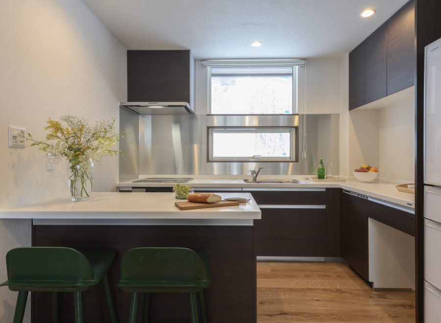 Modern kitchen with white countertops and dark brown cabinets.
