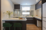 Modern kitchen with white countertops and dark brown cabinets.
