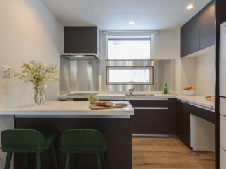 Modern kitchen with white countertops and dark brown cabinets.