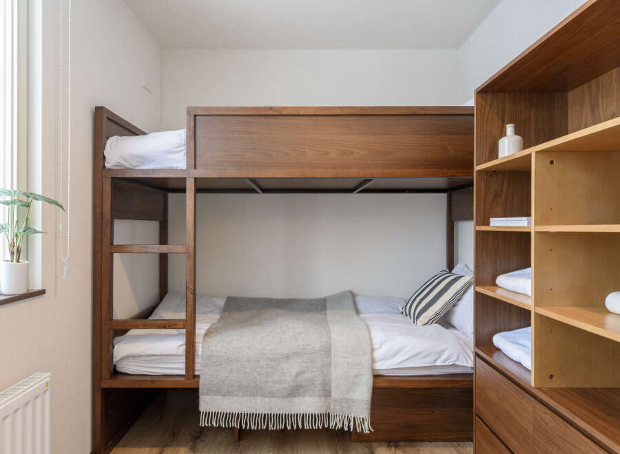Cozy bunk bed in a well-lit room, perfect for a relaxing stay.