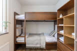 Cozy bunk bed in a well-lit room, perfect for a relaxing stay.
