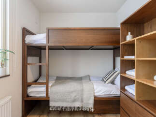 Cozy bunk bed in a well-lit room, perfect for a relaxing stay.