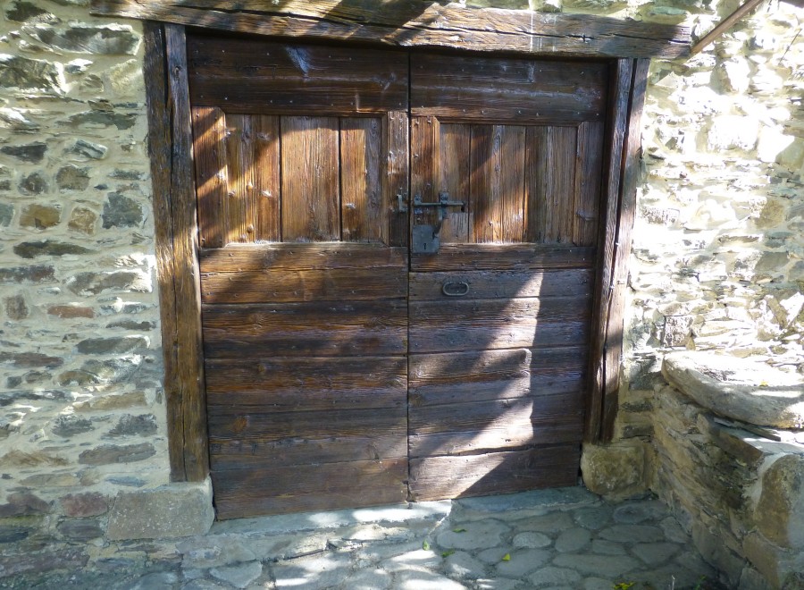 This charming property features rustic wooden doors, adding character and warmth to the stone facade.