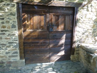 This charming property features rustic wooden doors, adding character and warmth to the stone facade.