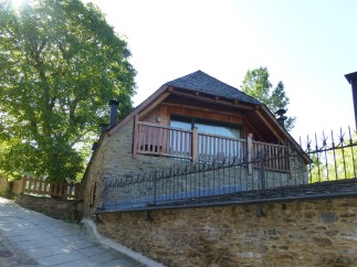 This charming stone house features a modern wooden addition with a balcony, offering stunning views.