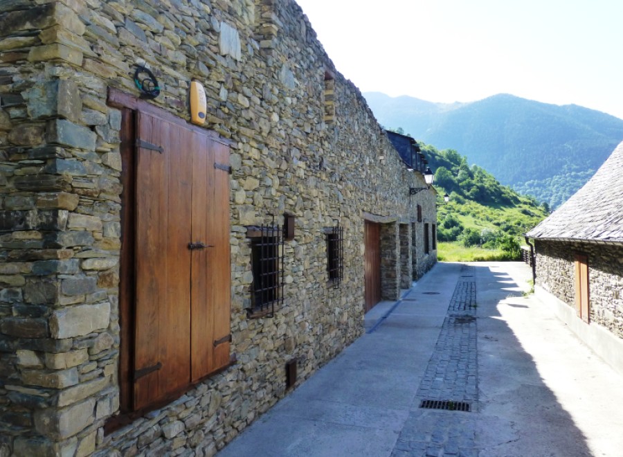 Picturesque stone buildings line a narrow street, showcasing rustic charm and traditional architecture.