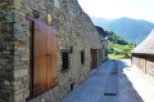 Picturesque stone buildings line a narrow street, showcasing rustic charm and traditional architecture.
