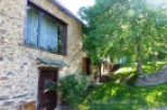 This charming stone house boasts a picturesque setting with a lush green lawn and mature trees.