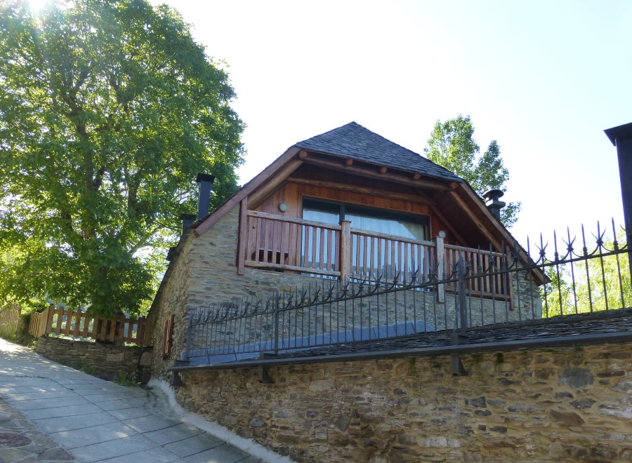 This charming stone house features a modern wooden addition with a balcony, offering stunning views.