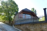 This charming stone house features a modern wooden addition with a balcony, offering stunning views.