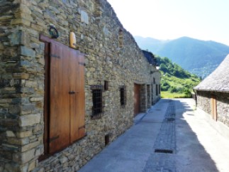Picturesque stone buildings line a narrow street, showcasing rustic charm and traditional architecture.