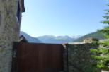 Mountain view property with rustic stone walls and a modern metal gate.