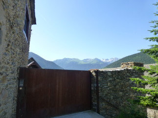 Mountain view property with rustic stone walls and a modern metal gate.