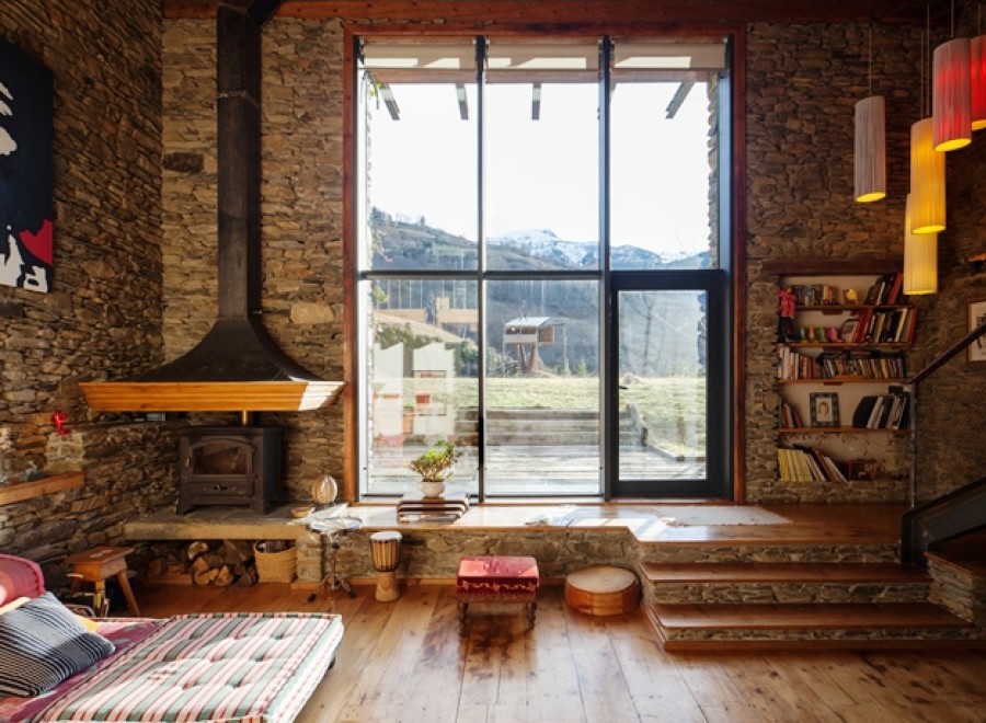 Rustic mountain retreat with floor-to-ceiling windows offering breathtaking views.