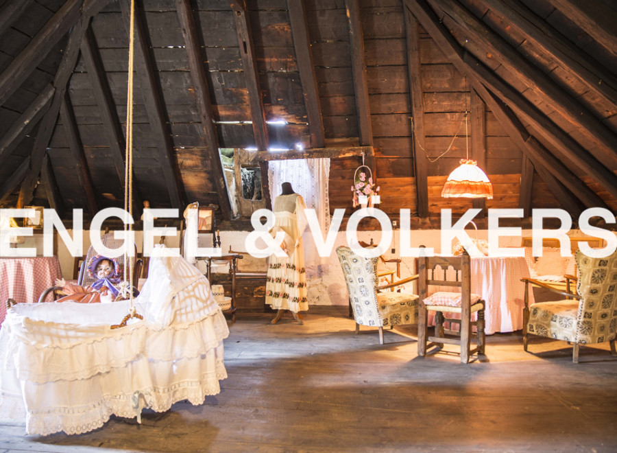 Charming attic space with exposed wooden beams and antique furnishings.