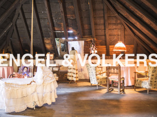 Charming attic space with exposed wooden beams and antique furnishings.
