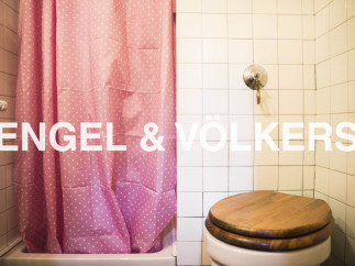 Charming bathroom with pink shower curtain and wooden toilet seat.
