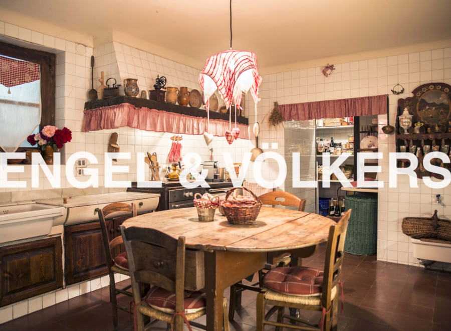 Rustic country kitchen with wooden table and chairs, antique cookware and charming decor.