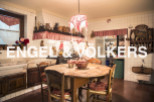 Rustic country kitchen with wooden table and chairs, antique cookware and charming decor.