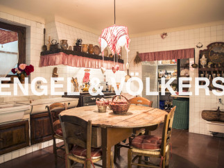 Rustic country kitchen with wooden table and chairs, antique cookware and charming decor.