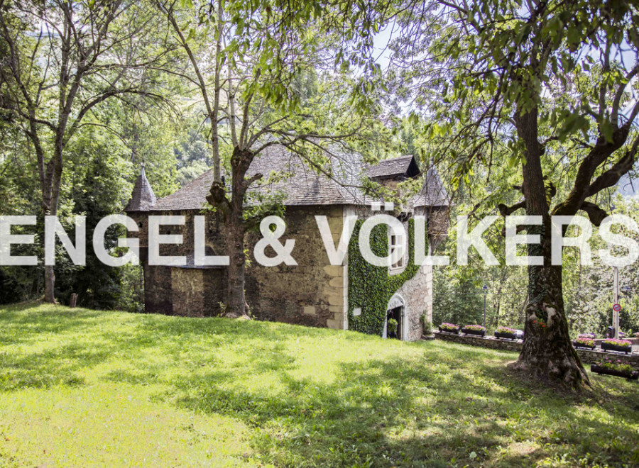 Discover this charming stone house nestled in a lush green landscape.