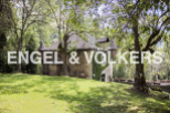 Discover this charming stone house nestled in a lush green landscape.