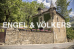 This charming stone house boasts a unique turret and ivy-covered walls, creating a picturesque setting.