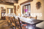 Rustic farmhouse with a charming dining area featuring a long wooden table and antique chairs.