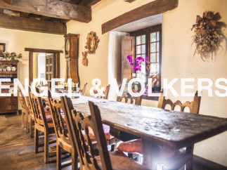 Rustic farmhouse with a charming dining area featuring a long wooden table and antique chairs.