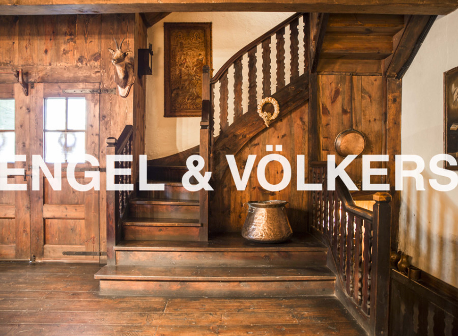 This stunning property boasts a grand wooden staircase, antique copper cookware, and unique wooden wall paneling.