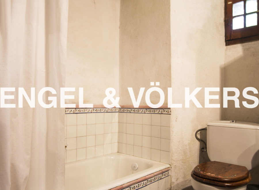 Rustic bathroom with vintage charm, featuring a bathtub, toilet, and shower curtain.