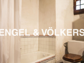 Rustic bathroom with vintage charm, featuring a bathtub, toilet, and shower curtain.