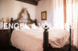 Charming bedroom with antique wooden bed and hand-painted headboard.