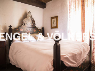 Charming bedroom with antique wooden bed and hand-painted headboard.