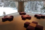 Experience tranquility in this stunning space, featuring a breathtaking view of a snow-covered forest.