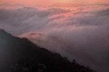 Witness a breathtaking sunrise over a sea of clouds.