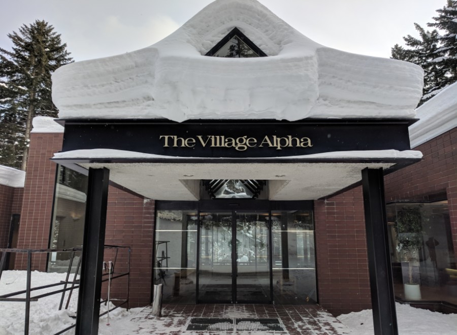 The Village Alpha welcomes guests with a charming entrance, perfect for a winter getaway.