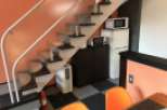 This cozy apartment features a unique design with a staircase leading to the upper level.