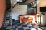 This modern apartment boasts a unique spiral staircase and stylish orange accents.