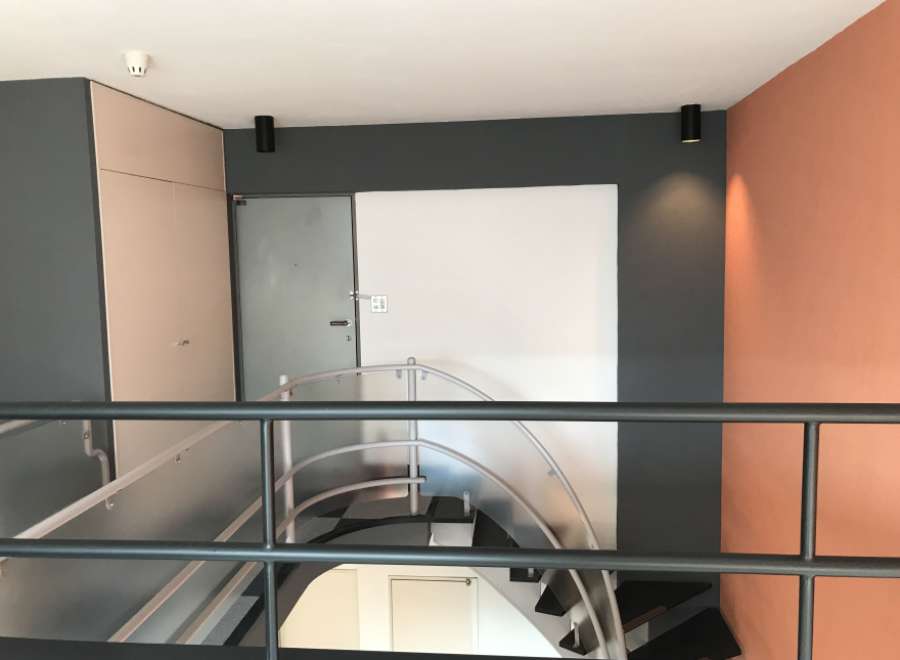 This property features a modern design with a stylish staircase and a unique color palette.