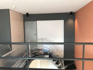 This property features a modern design with a stylish staircase and a unique color palette.