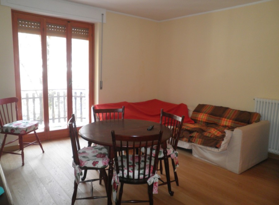 This charming property features a cozy living space with a round dining table and chairs, perfect for intimate gatherings.