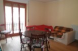 This charming property features a cozy living space with a round dining table and chairs, perfect for intimate gatherings.