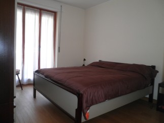 Cozy bedroom with a comfortable bed and a large window that lets in plenty of natural light.