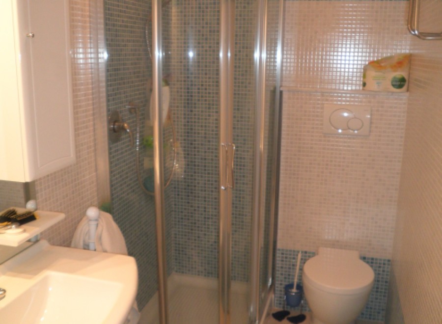 This bathroom features a modern shower with a glass enclosure, perfect for a refreshing start to your day.