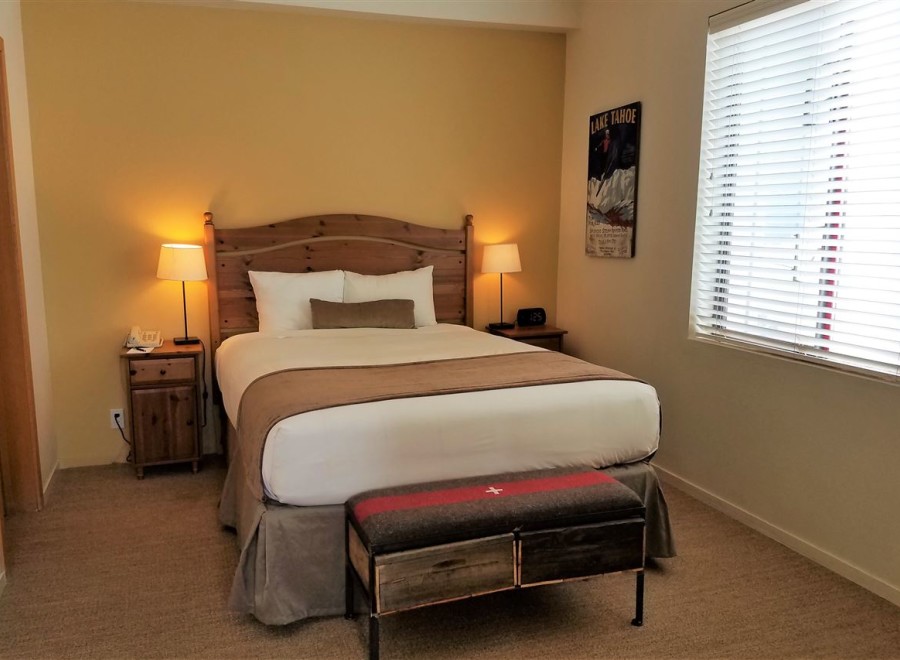Cozy up in this inviting hotel room, featuring a comfortable bed and warm lighting.