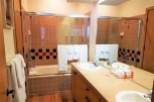 This bathroom features a classic design with tiled walls and a bathtub-shower combo.