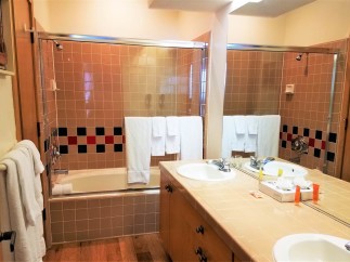 This bathroom features a classic design with tiled walls and a bathtub-shower combo.