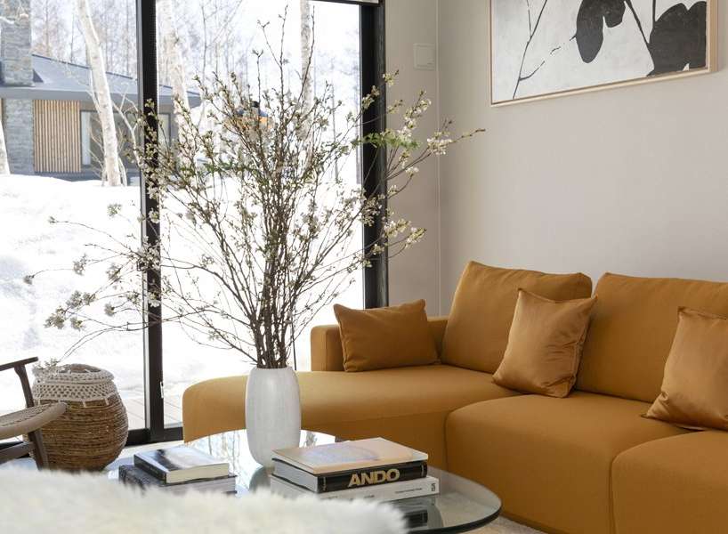 This stunning living room boasts a spacious sectional sofa in a rich mustard yellow, complemented by plush throw pillows.